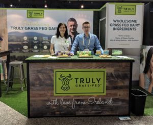 a photo of a man and woman at a truly grass fed stall