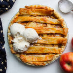 An image of a cheesey apple pie with ice cream melting on it