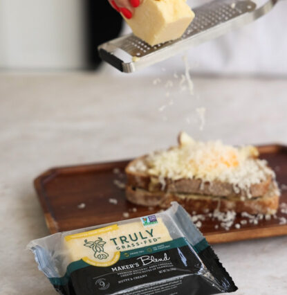 maker;s blend cheese being grated onto bread