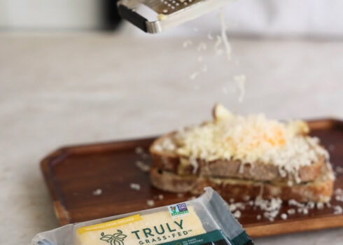 maker;s blend cheese being grated onto bread