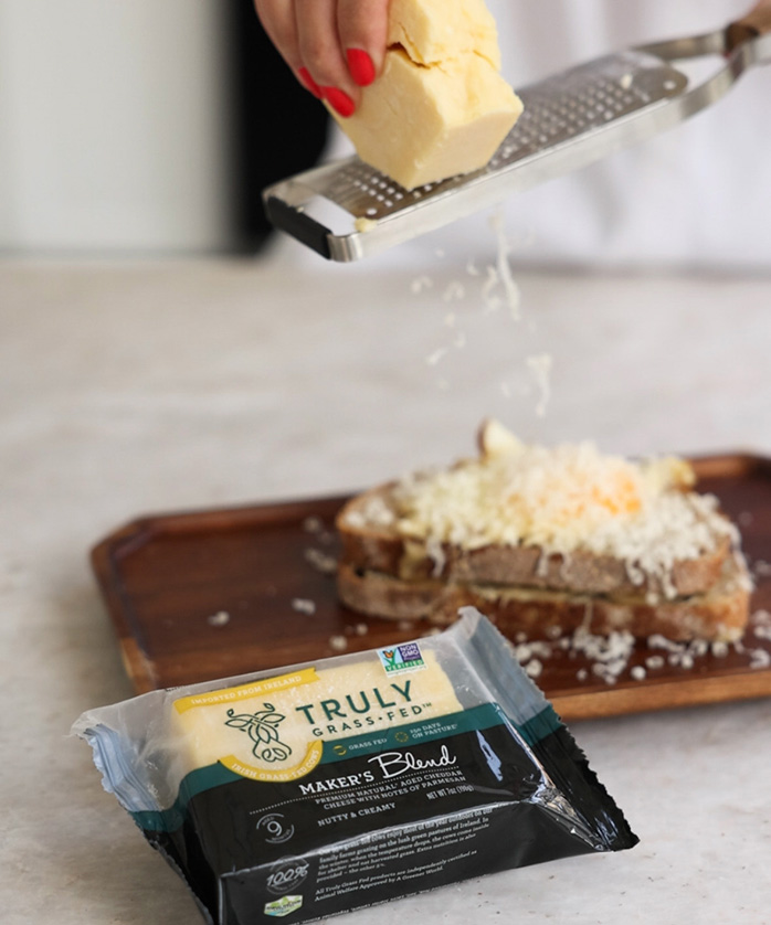 maker;s blend cheese being grated onto bread