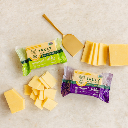 natural sharp cheddar cheese wedge and slices of cheese cut