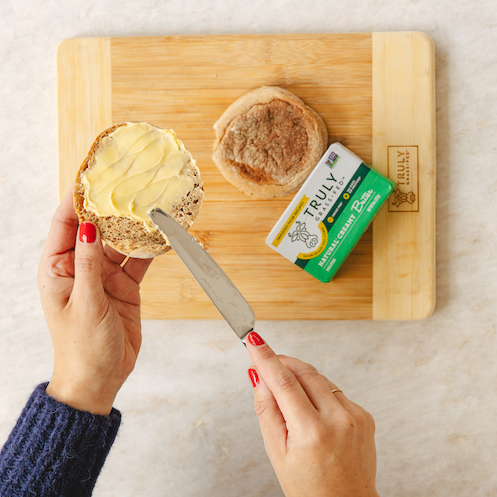 natural creamy salted butter being spread on a muffin